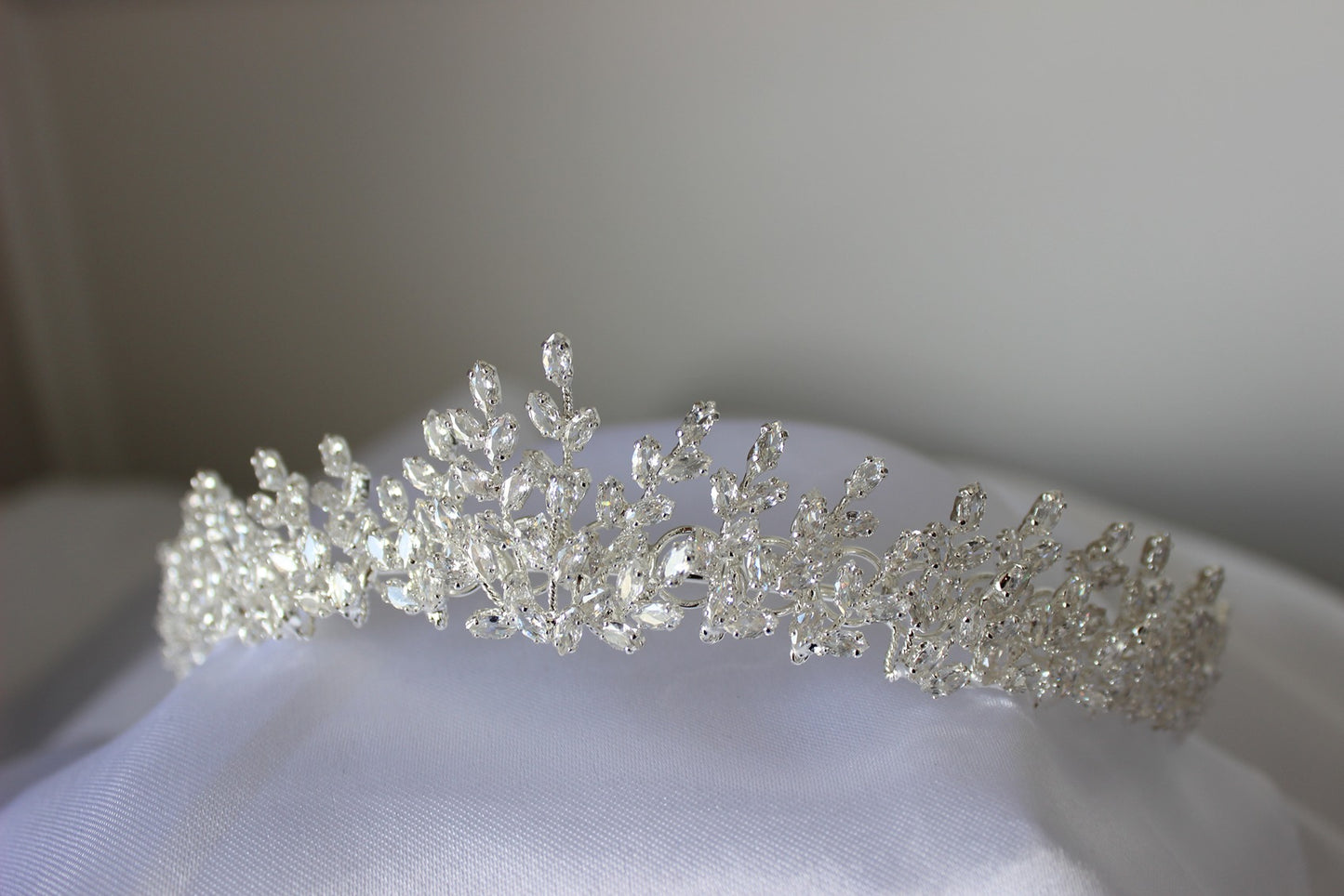 Silver tiara on a white fabric background